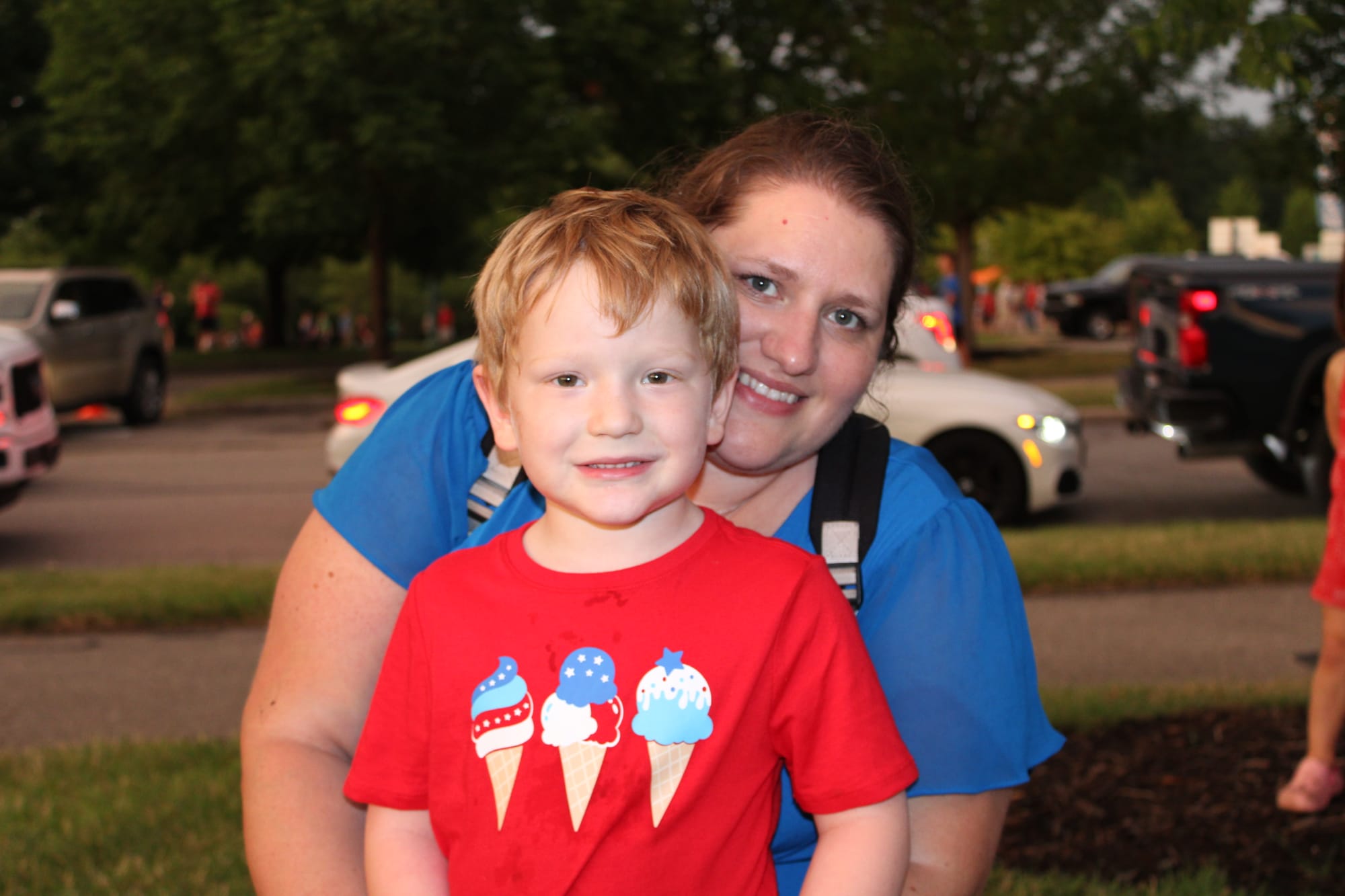 Brittany Kyger kneels behind her son Daniel Kyger, both smiling