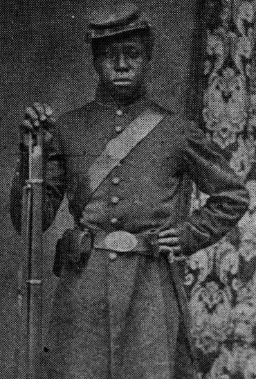 Black and white photo of Robert J. Jones standing in military uniform with a rifle