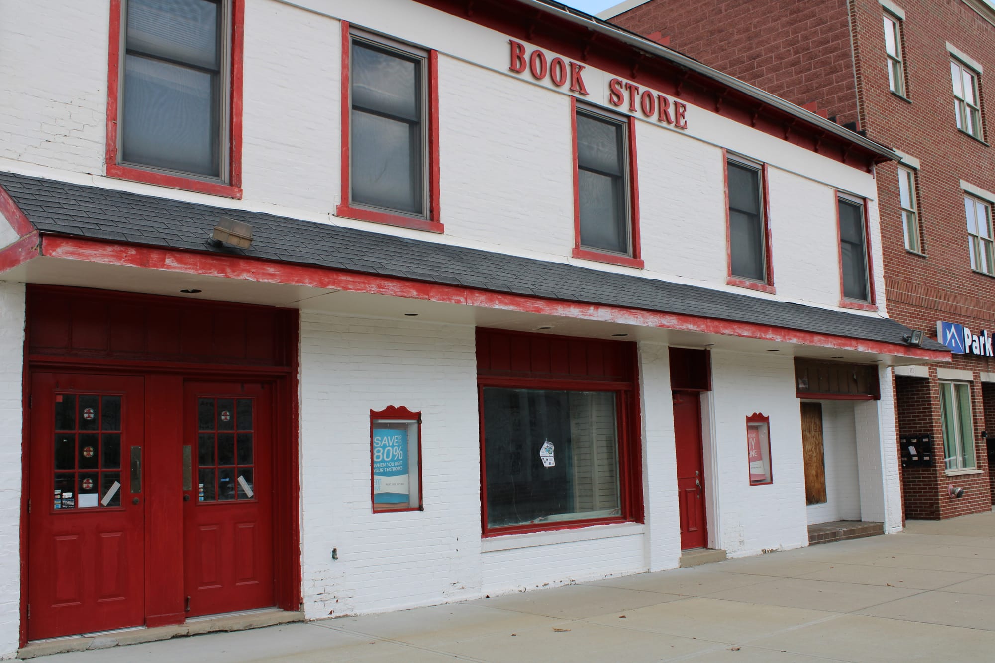 A two-story red and white building with "Book Store" written on the top floor