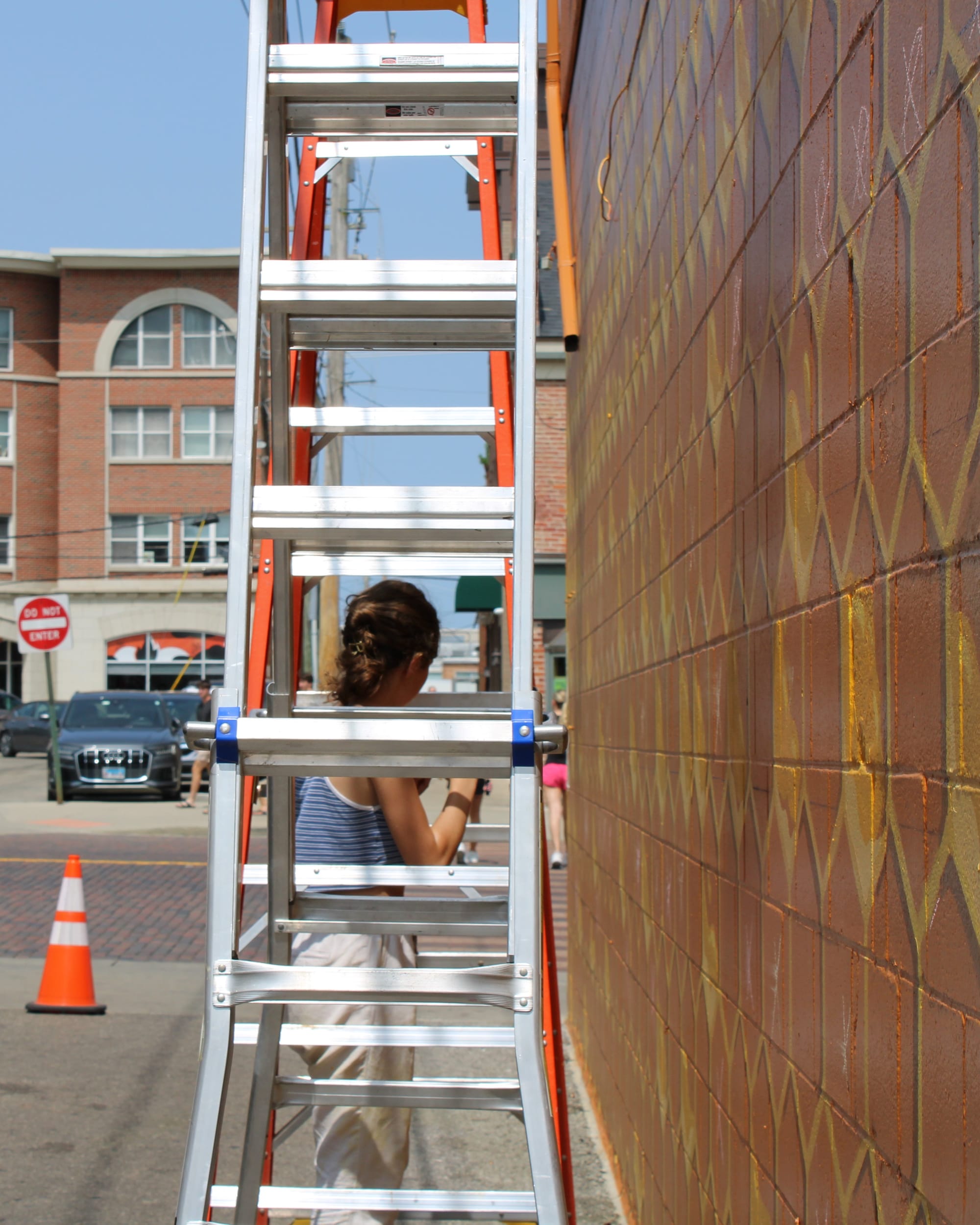 Natasha Isaeva stands under a ladder while painting