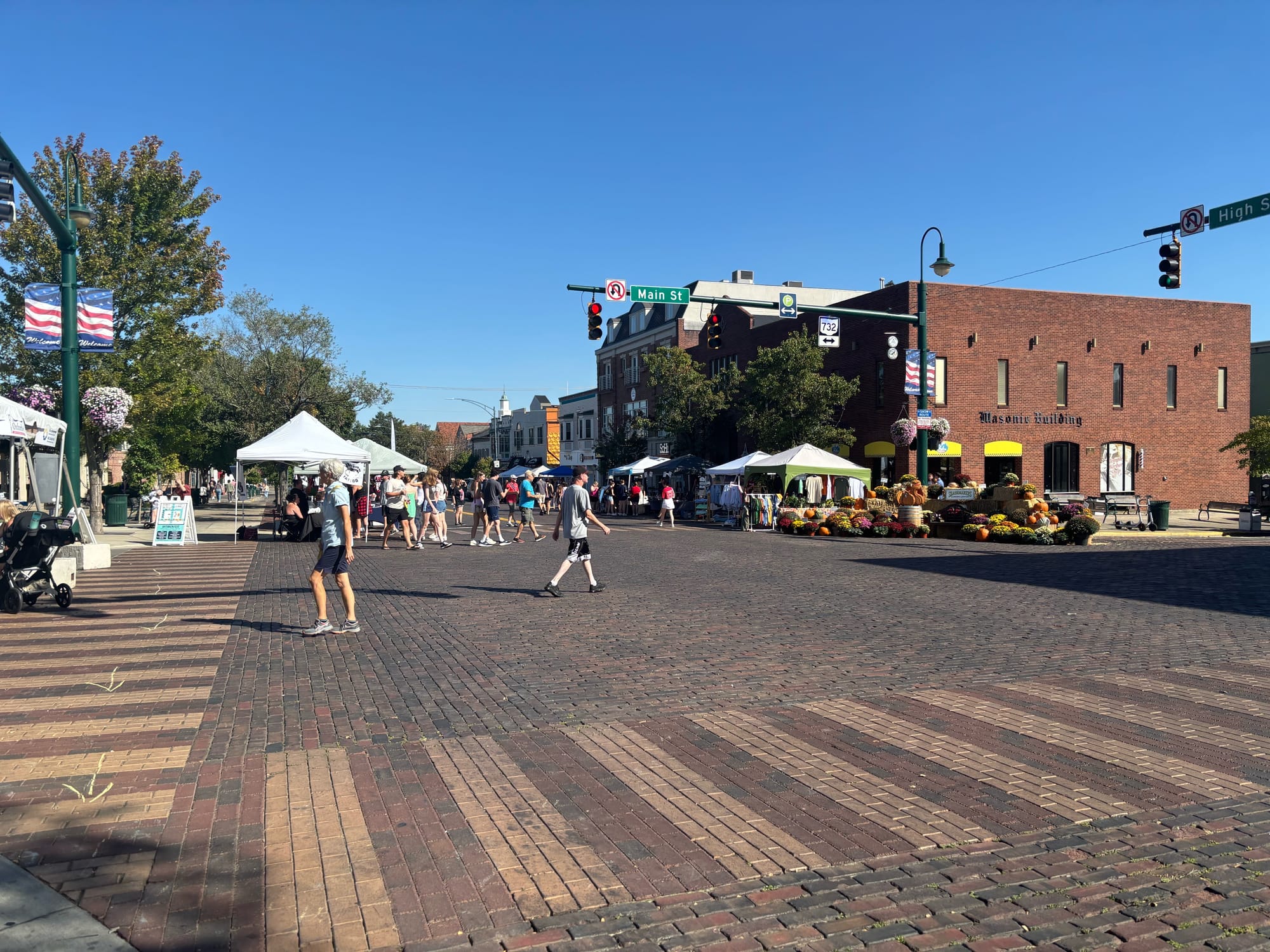 A view of the events, people walking and tents from Main Street