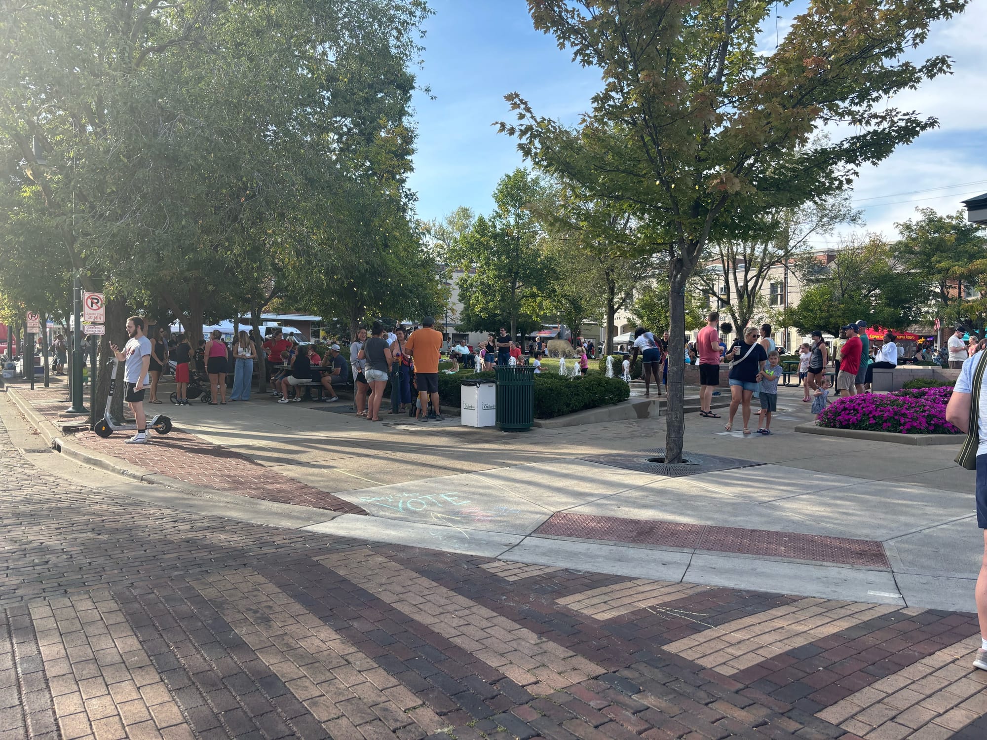 People Uptown celebrating the Oxtoberfest event in front of a road and surrounding trees