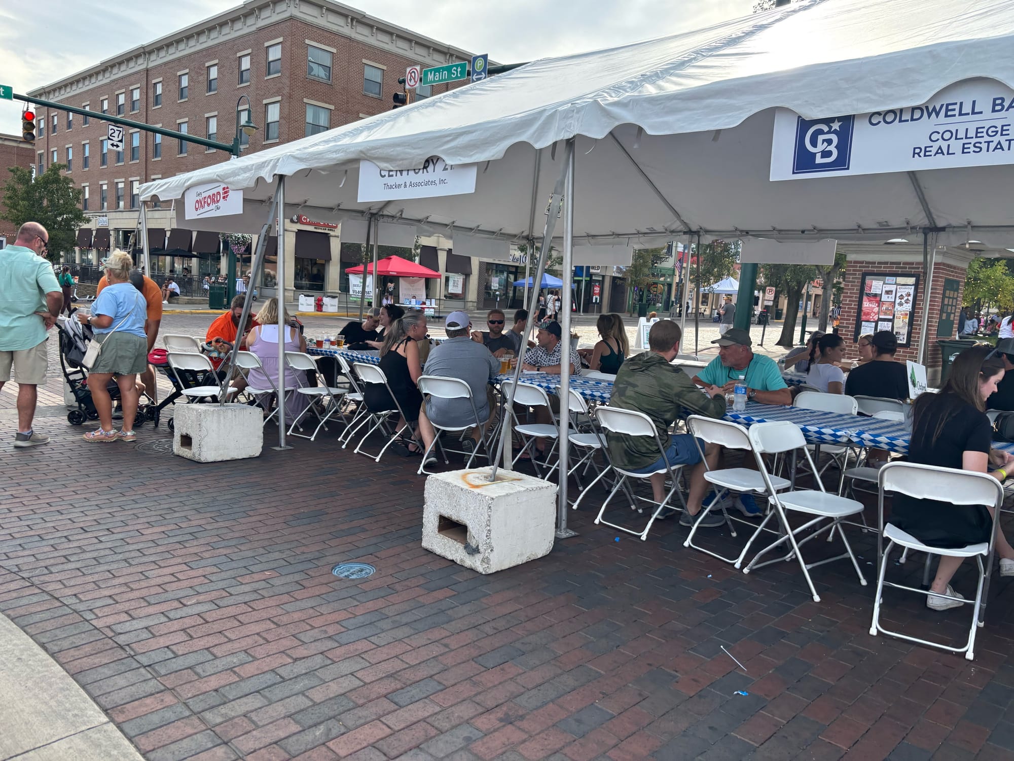 People gathered at tables under a tent eating food