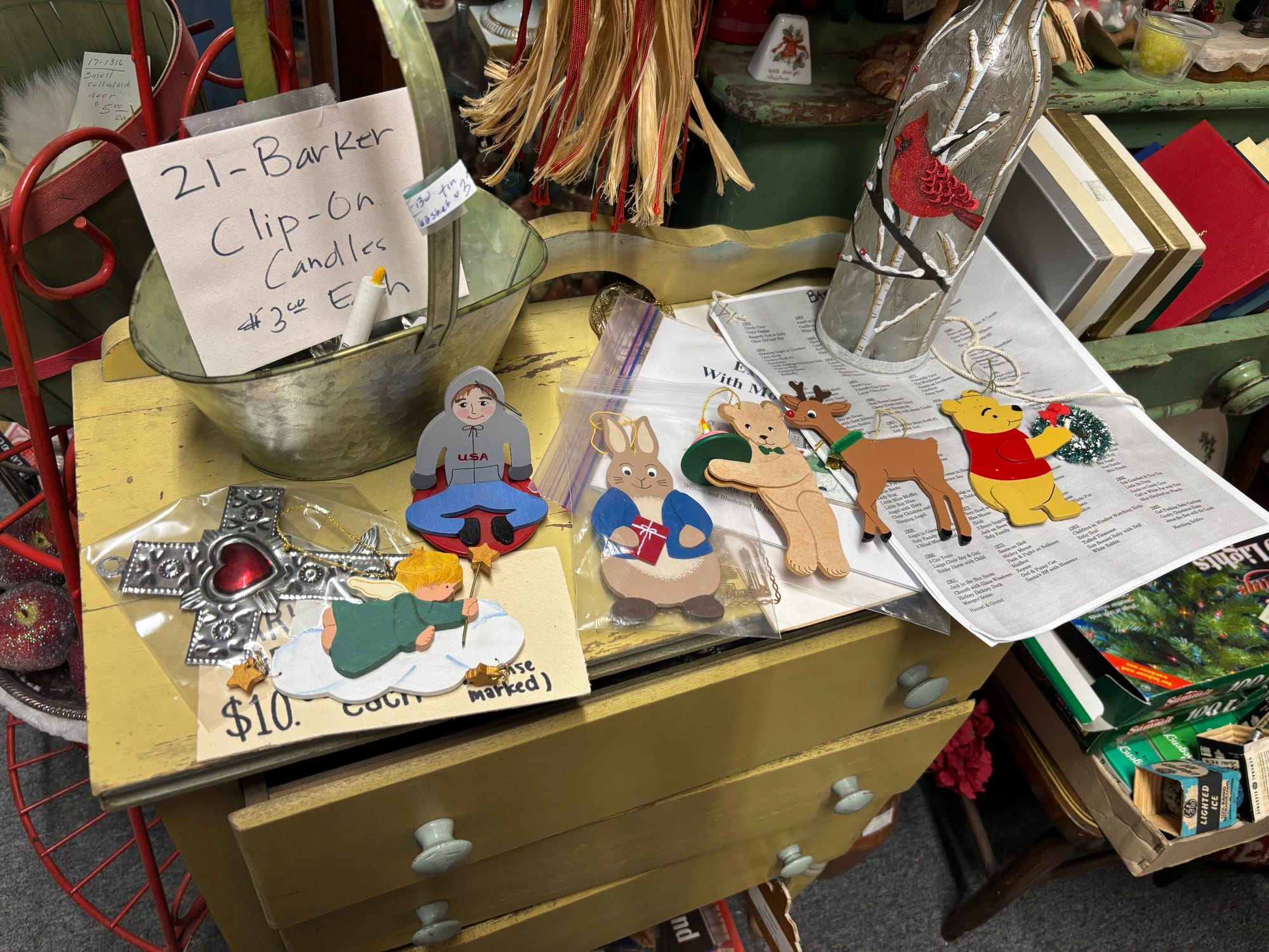 A variety of different Barker Ornaments on display on top of a yellow dresser