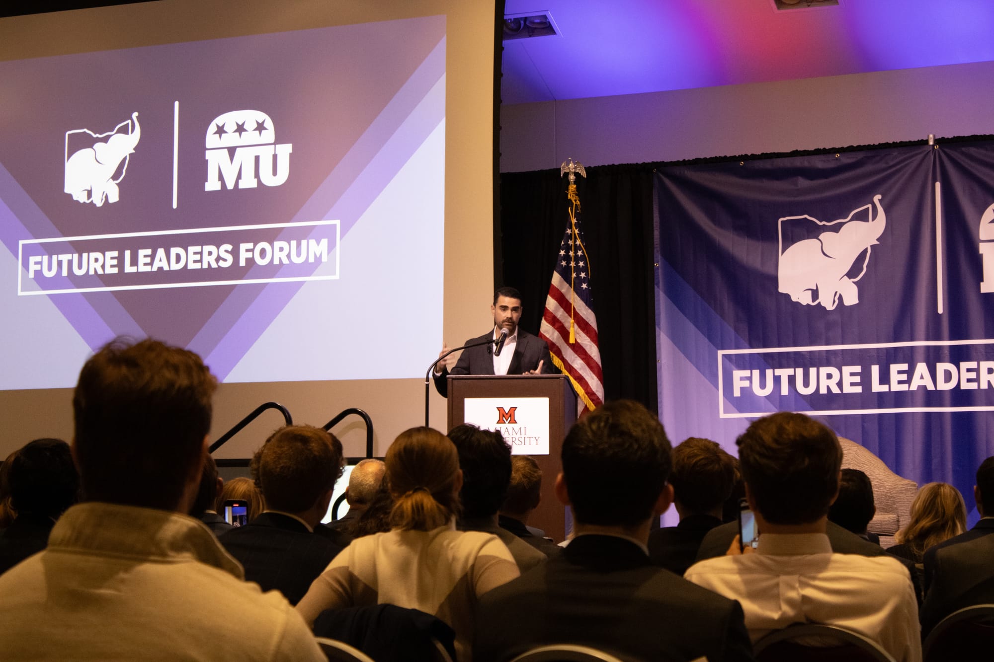 Ben Shapiro stands on stage in front of an audience