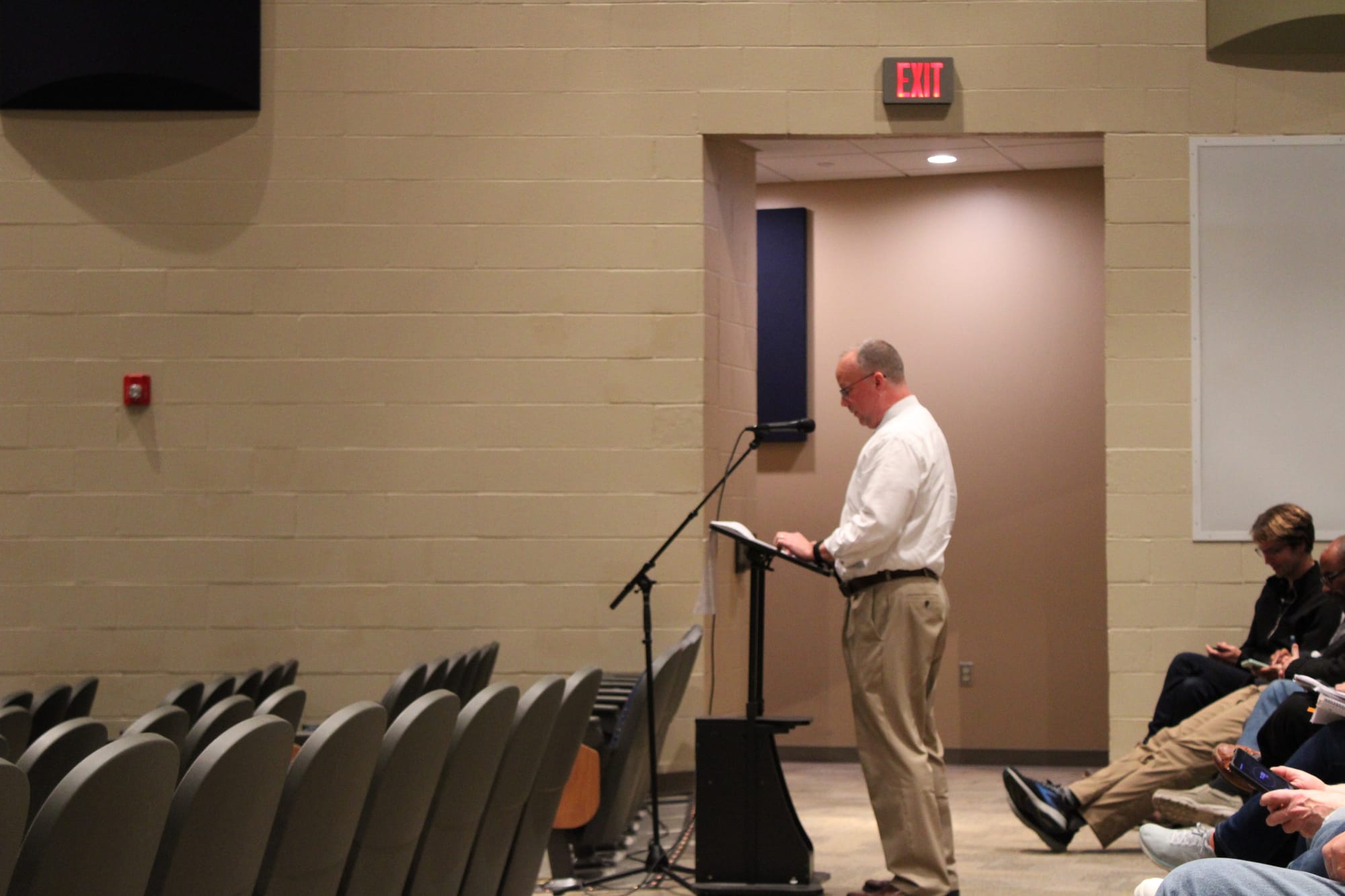 Ted Caudill stands in front of a microphone in an auditorium