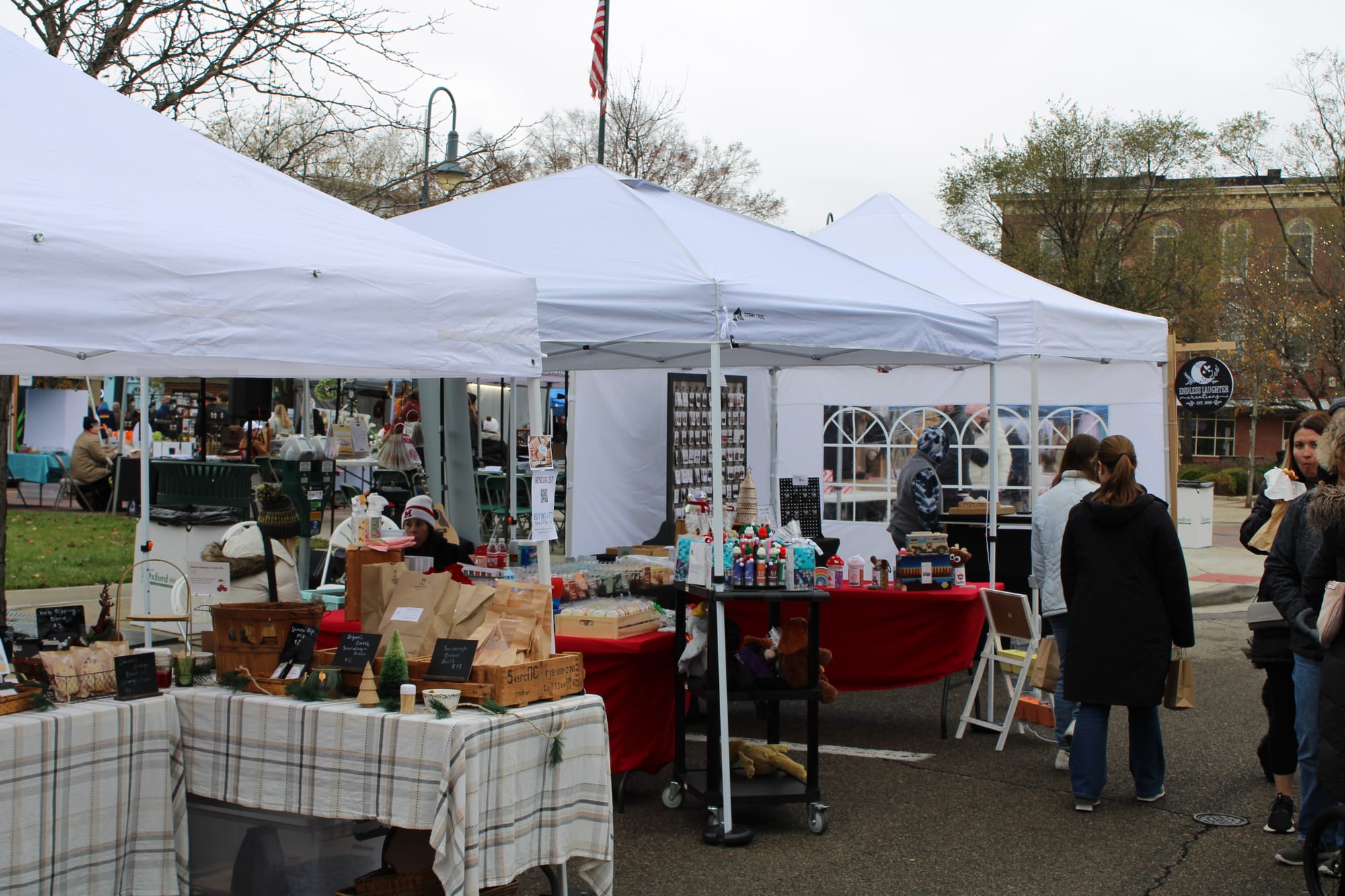 Three different tents where vendors are selling their items.