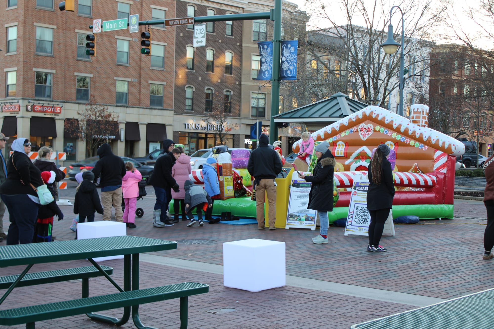 People gathering around a gingerbread inflatable in Uptown