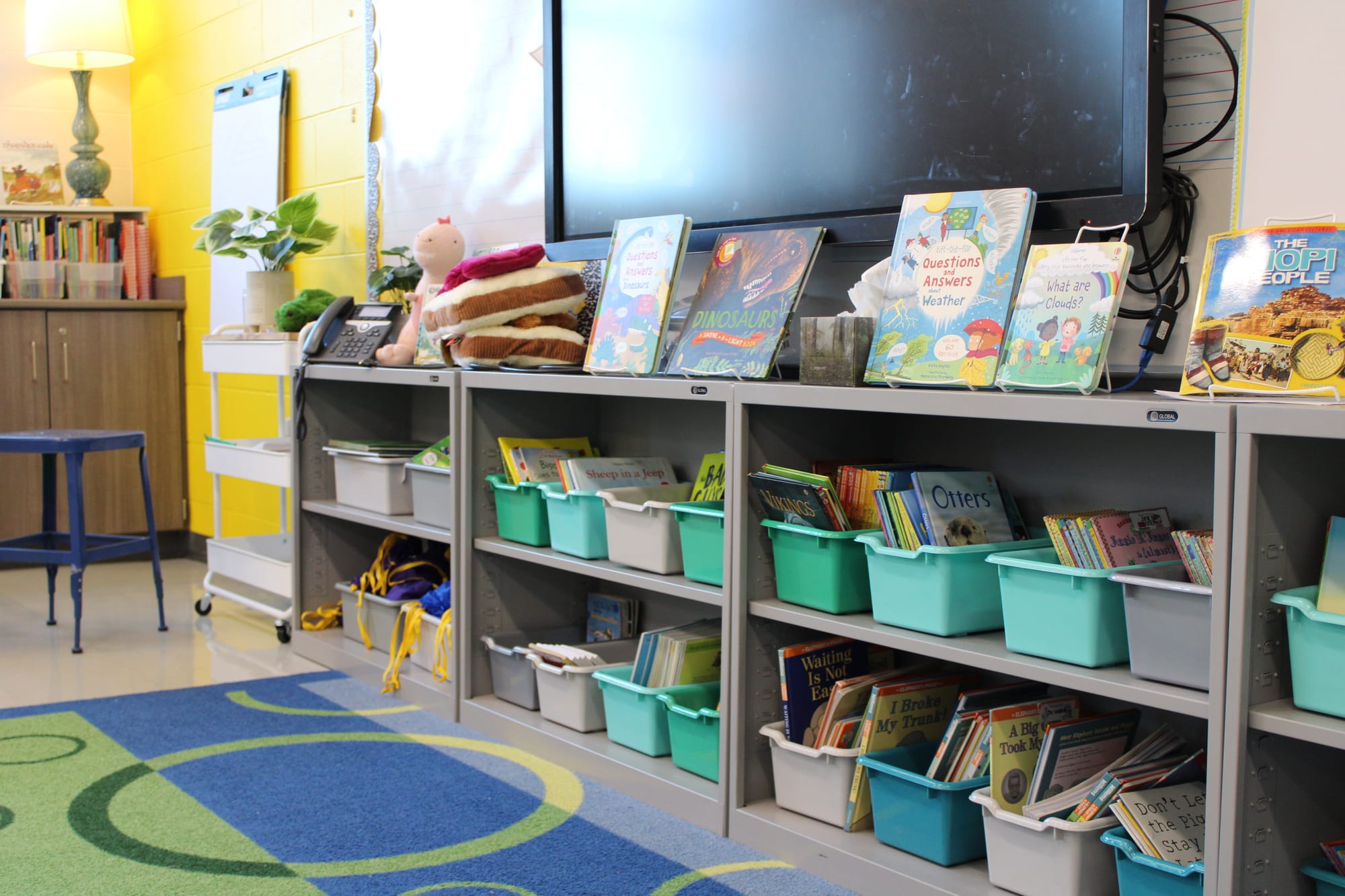 Shelves filled with colorful bins and books line the walls in Jamie Corbin's classroom