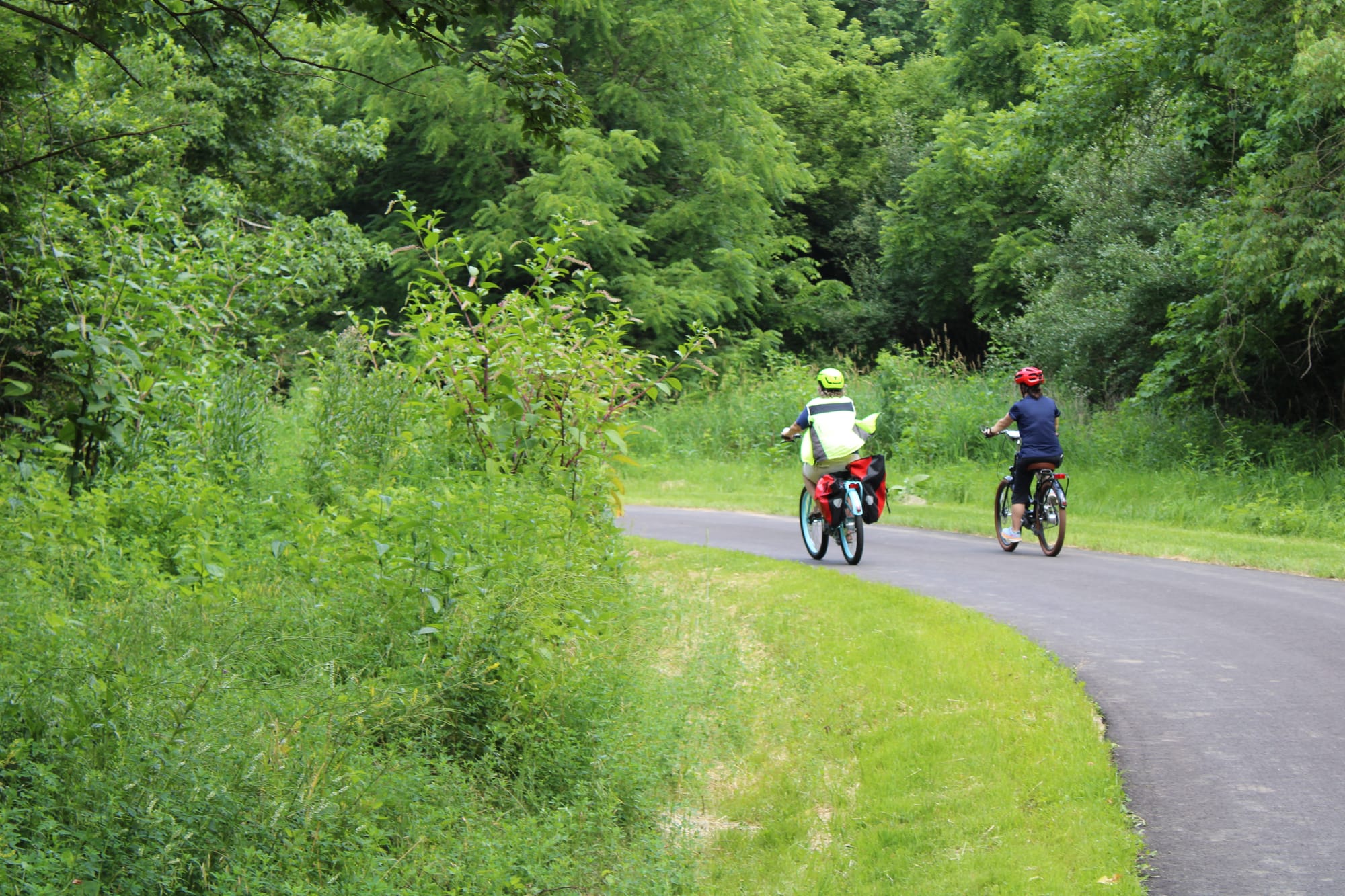 Two cyclists bike on the Oxford Area Trail