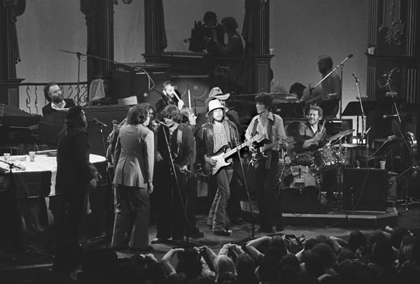 Black and white photo of The Band performing on stage with Bob Dylan