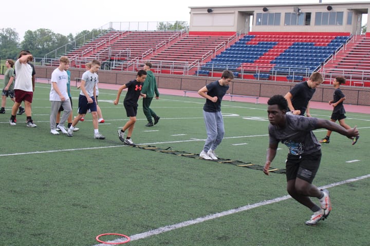 Young athletes run on a football field