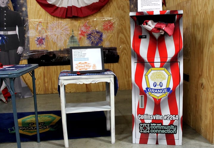 In a wooden display at the Butler County Fair, a red and white flag disposal box is showcased. Photo by Taylor Stumbaug