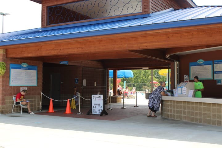 Employees and one guest stand under the entrance to the Oxford Aquatic Center