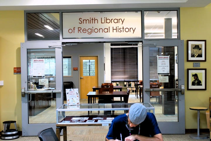 A man works in front of the interior door to Smith Library of Regional History