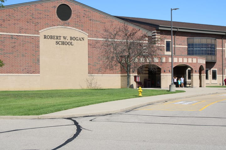 A family walks into the entrance at Bogan Elementary