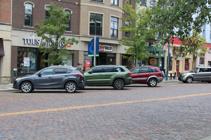 Cars park in diagonal spaces along High Street