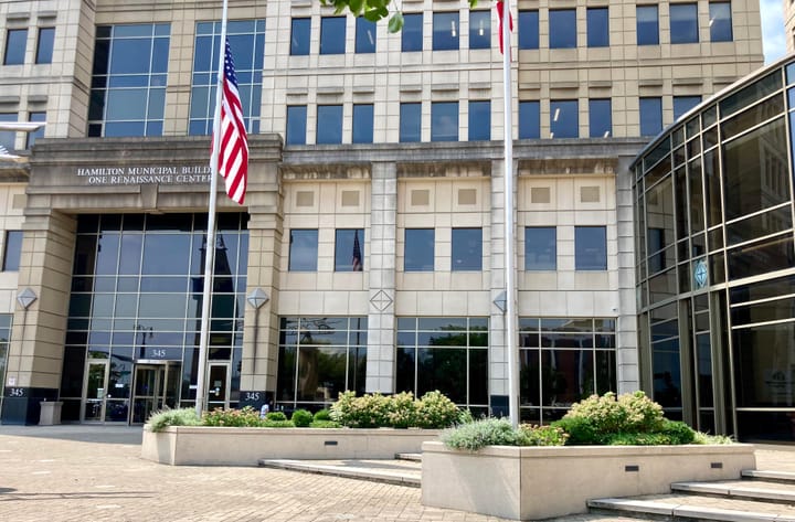 A tall government building with American flags out front.