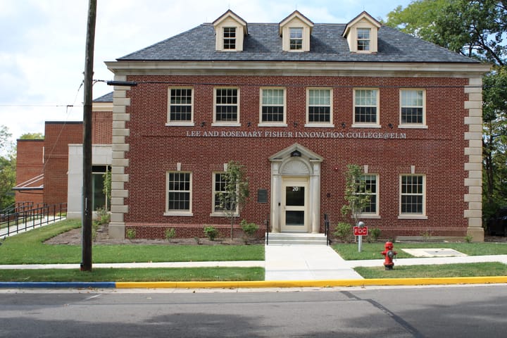 A three-story brick building labeled "Lee and Rosemary Fisher Innovation College@Elm"