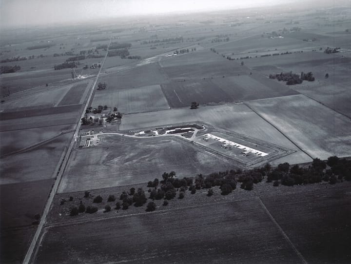 A black and white archival aerial photo of a Nike missile base among farmland