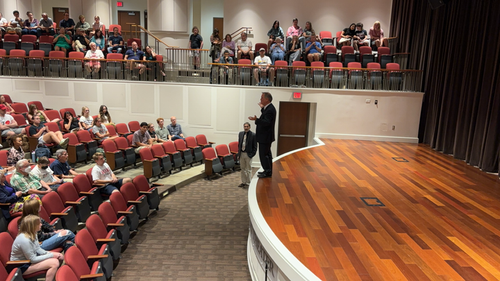 Robert Bilott stands on the edge of the Harr T. Wilks Theater stage as he lectures students and community members