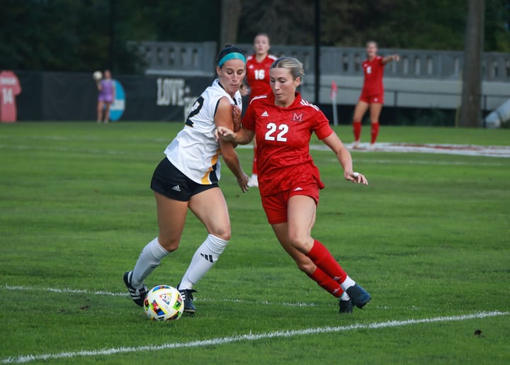 Makenna Morrison chases a soccer ball, along with an opposing athlete