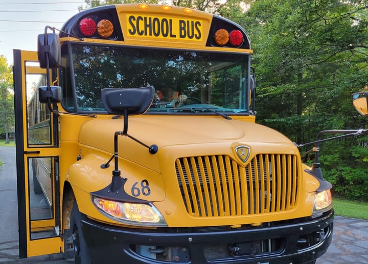 A yellow school bus with open doors