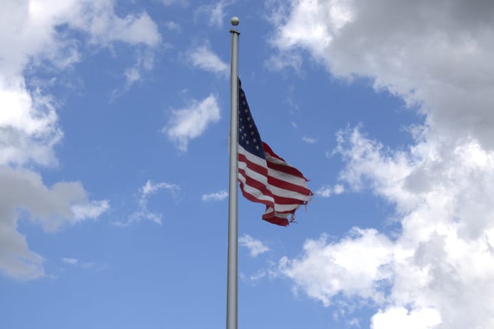 A view of the American flag in a cloudy sky