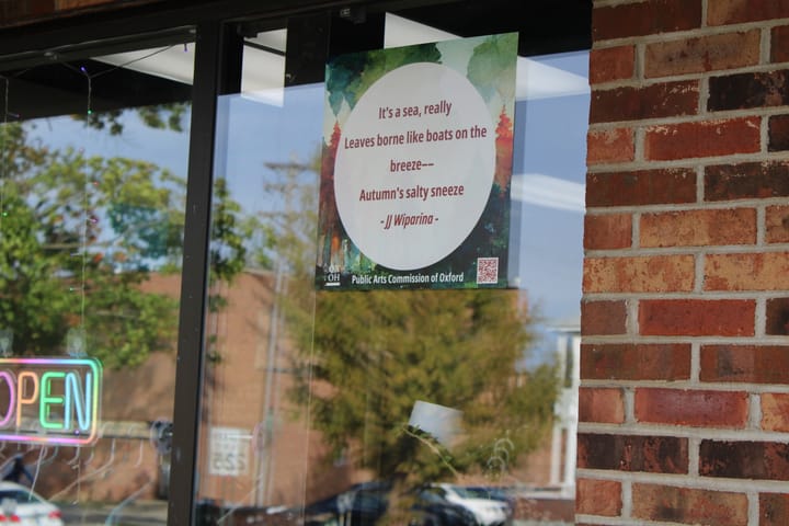 A view of the entrance to Uptown Threads featuring a haiku window cling