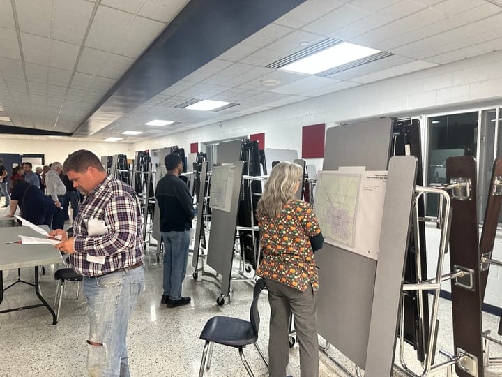 Residents look at maps pinned up around the Talawanda Middle School cafeteria