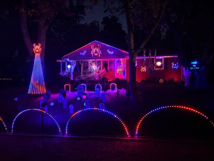 A view of red and purple lights in front of Brian Gardner's house as part of his Halloween display