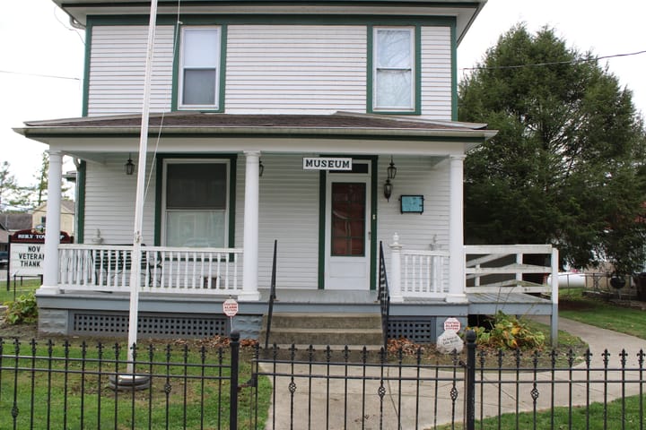 Exterior of the Hammond House Museum, a white house with green trim and a blue porch