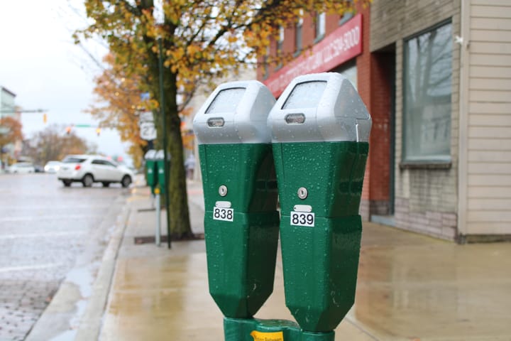 A green and silver parking meter on High Street