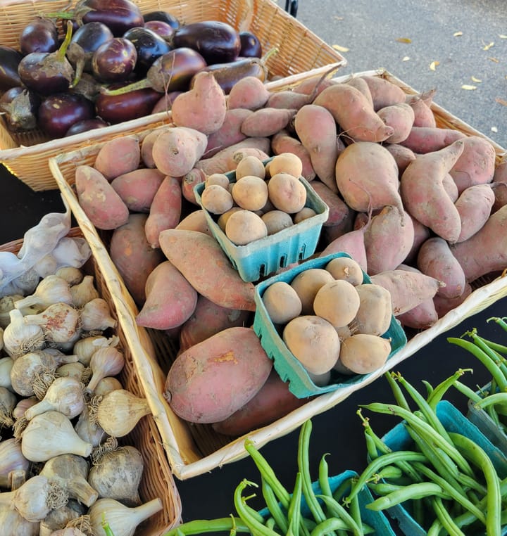 Baskets full of potatos, green beans and garlic