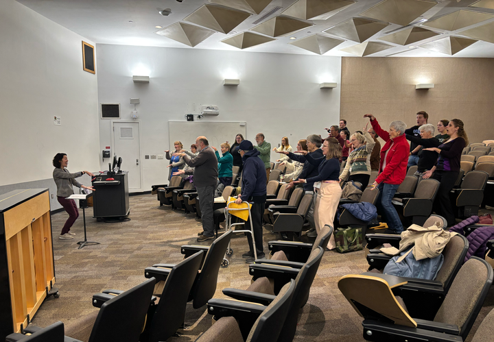 The choir practicing warmups prior to their rehearsal.