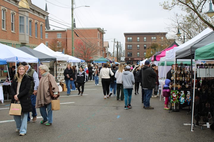 Guests walking through the streets of Uptown and passing different vendors in tents.