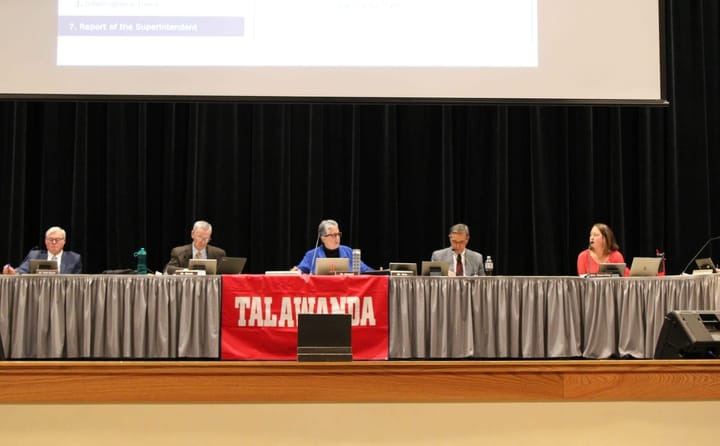 Talawanda board members sit behind a table on stage