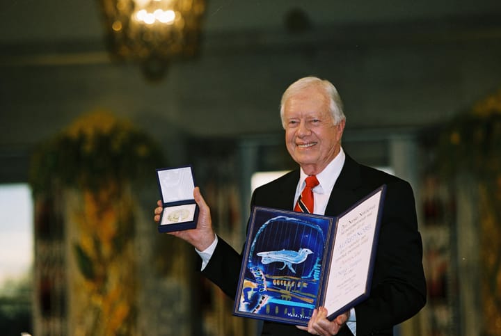 Jimmy Carter holds up a Nobel Peace Prize