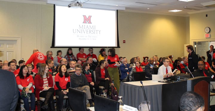 FAM members in red shirts fill the public seating for a Miami Board of Trustees meeting