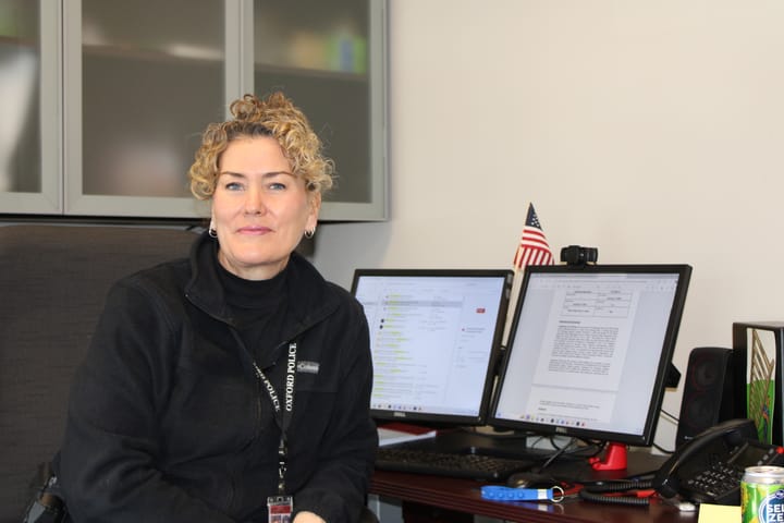 Lara Fening sits in front of her computer monitors