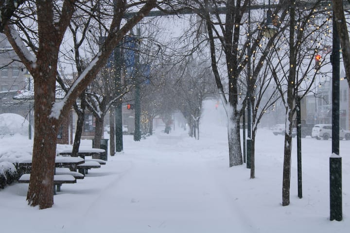 Sidewalks Uptown covered in snow during a storm