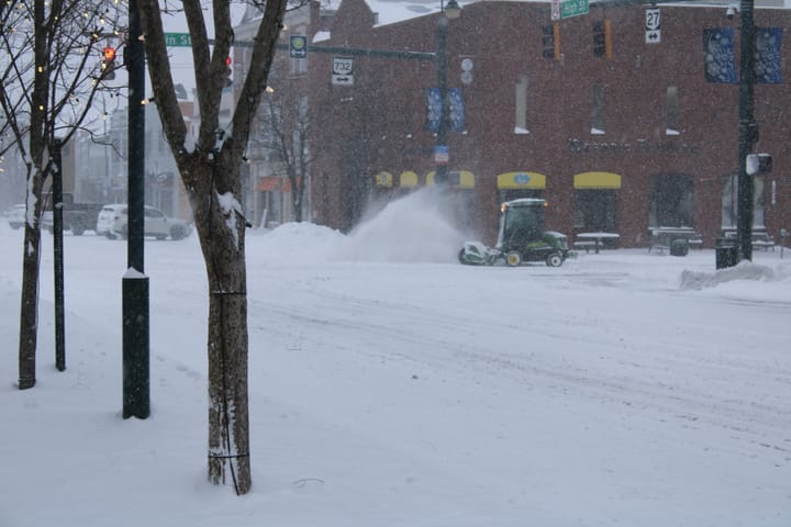 A small vehicle plows snow in front of Skyline Chili on High Street