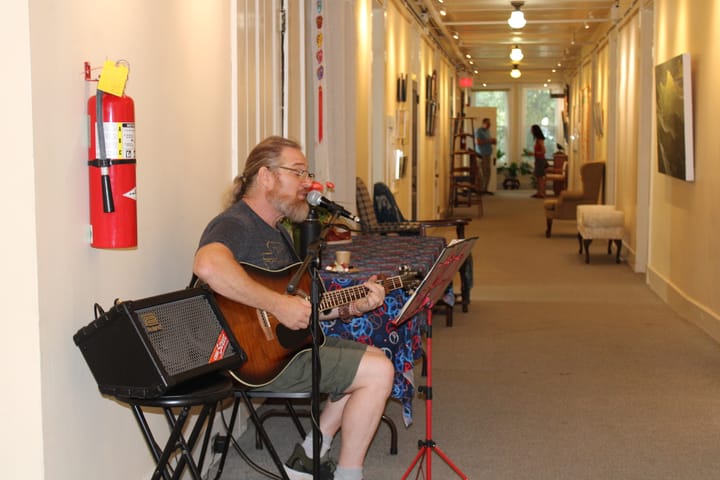 Joe Prescher plays guitar in an OCAC hallway