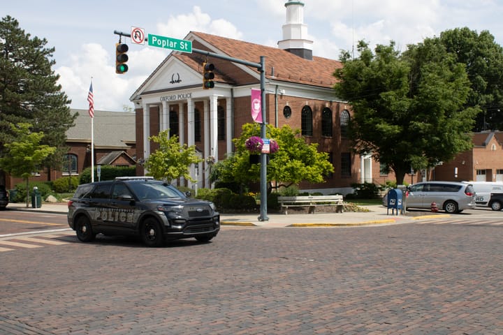 An MUPD cruiser drives in front of the Oxford Police Department