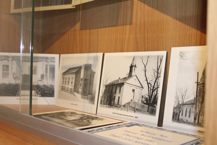 Several photos of historic church buildings in a display case