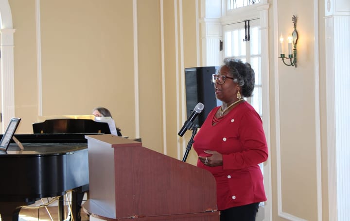 Vanessa Cummings stands at a lectern and sings