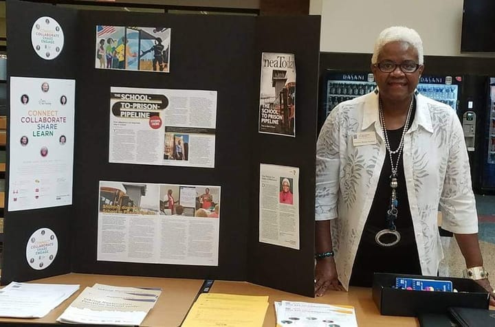 Deloris Rome Hudson stands next to a poster presentation about the school-to-prison pipeline