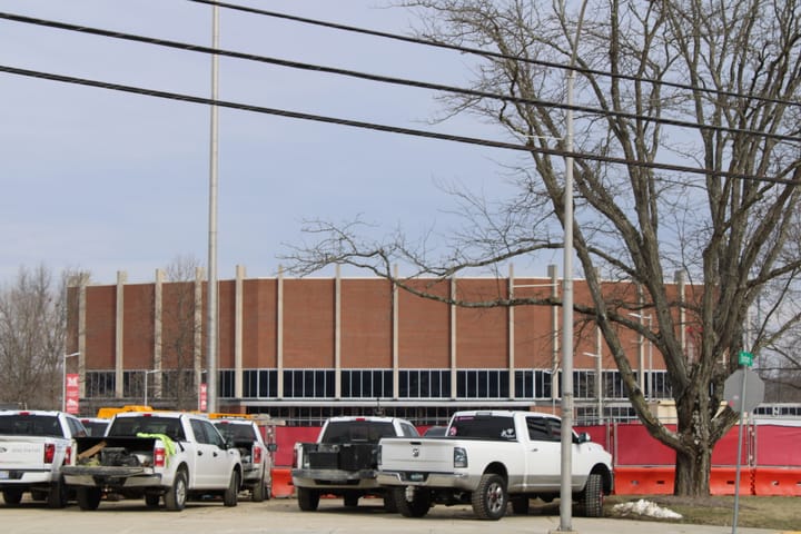 Several pickup trucks parked in front of Millett Hall