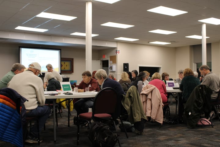 Members of OASH sit in a meeting room around tables